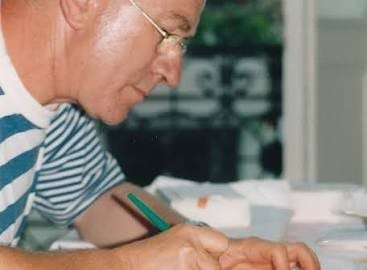 Jean-Pierre Geay calligraphiant les couvertures de « Sombrer dans l’infini » avec Bernard Alligand le 4 août 1995. Source : Wikipédia